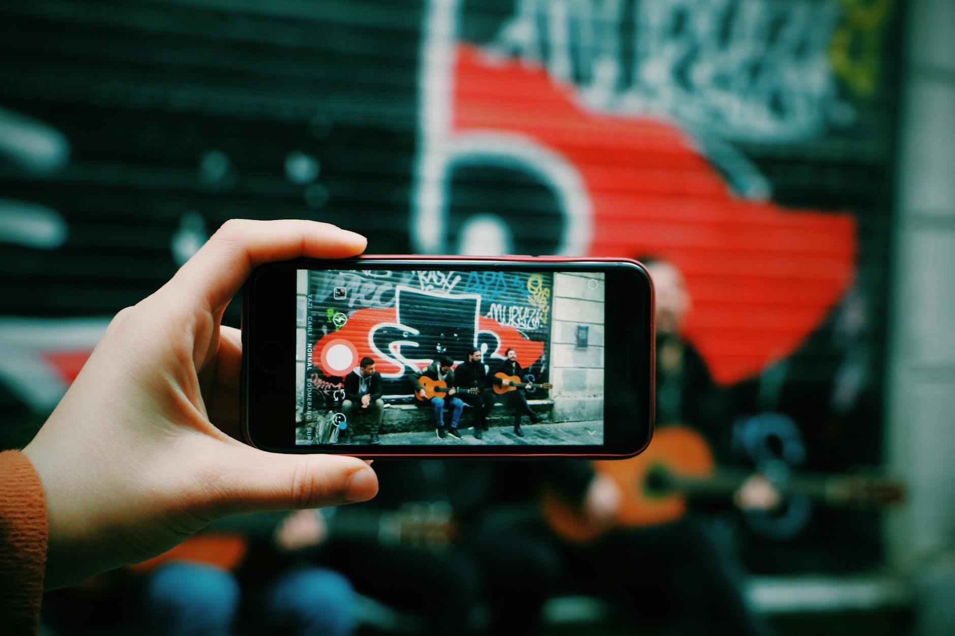 Uliczni muzycy gitarowi uchwyceni smartfonem w centrum miasta